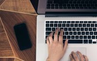 Frau schreibt auf Laptop Tastaur